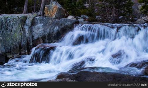 White frothing water as it flows rapidly downward.. Water Over Rocks