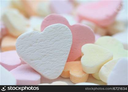 white fruit candy heart on a pile of candy hearts