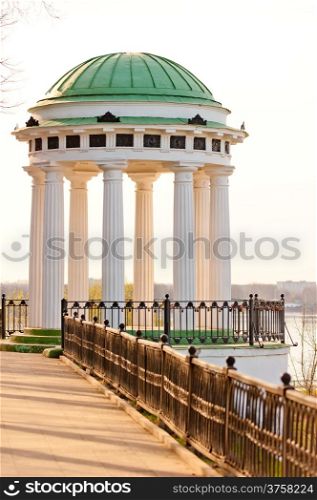 white gazebo with carved pillars on the waterfront