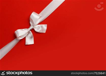 White gift bow on red background copy space for text holiday gift concept. White gift bow on red