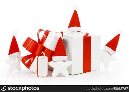 White gift box with red ribbon, stars with santa claus hats isolated on white background