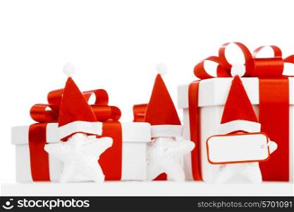 White gift box with red ribbon, stars with santa claus hats isolated on white background