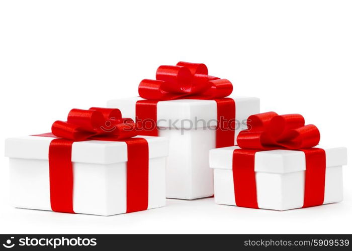 White gift boxes with red ribbon bows isolated on white background close-up