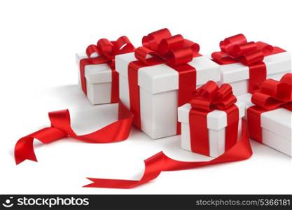 White gift boxes with red ribbons isolated on white