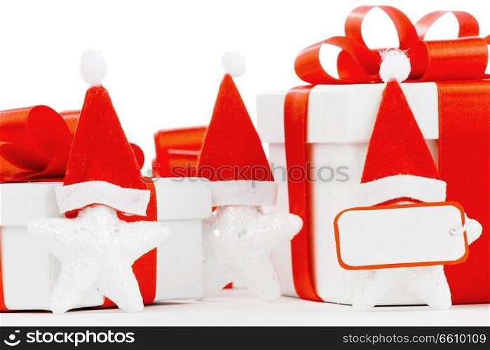 White gift boxes with red ribbons, stars with santa claus hats isolated on white background