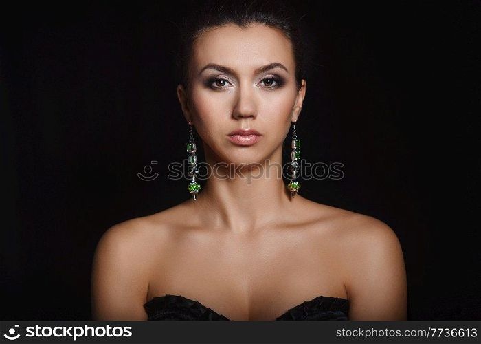 white girl brunette beauty portrait on black background with jewelry