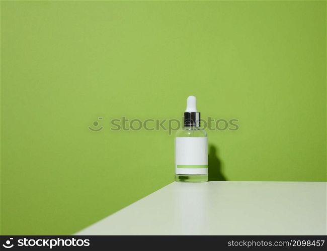 white glass bottle with a pipette and a empty white label. Container for cosmetics, serum and oil. Mockup skincare product