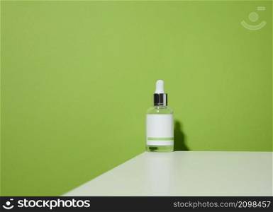 white glass bottle with a pipette and a empty white label. Container for cosmetics, serum and oil. Mockup skincare product