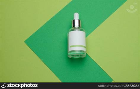 White glass bottle with a pipette and a empty white label. Container for cosmetics, serum and oil. Mockup skincare product, flat lay