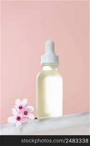White glass dropper bottle with white lid on white marble shelf, natural spring  background. SPA natural organic beauty product packaging design, branding. Beauty salon mockup, low angle view, below the eye line, looking up, hero view
