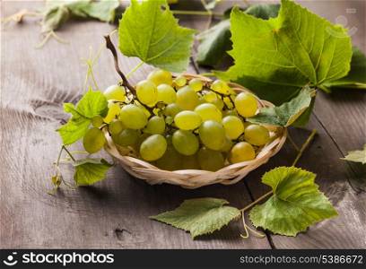White grape with leaves in the wooven plate