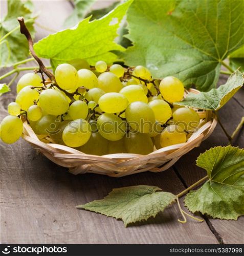 White grape with leaves in the wooven plate