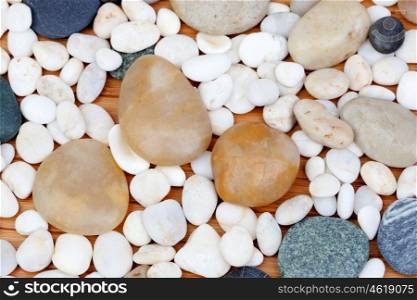 White, gray and brown stones river on wooden background