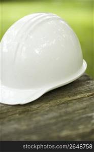 White hard hat on a wqooden table outdoors