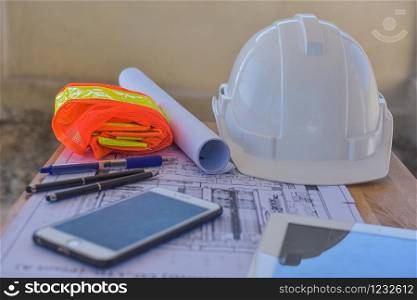 White hard hat Smart phone blueprint tool equipment on desk