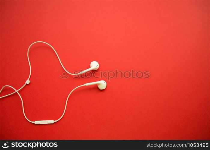 white headphones on red background with copy space.. white headphones on red background with copy space