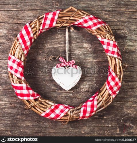 White heart and wreath over wooden old background