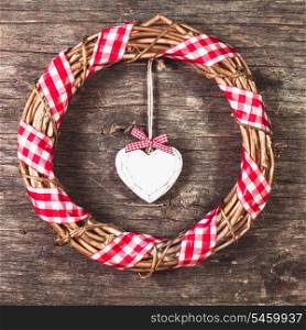 White heart and wreath over wooden old background