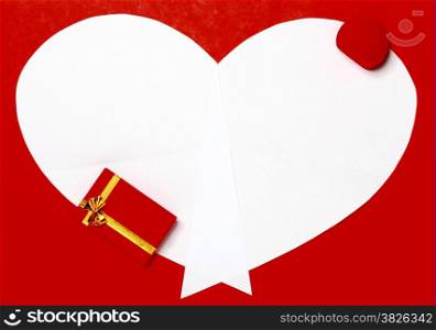 White heart paper on red background with two gift boxes. Valentine&rsquo;s Day or holiday greeting card. Heart symbol frame.
