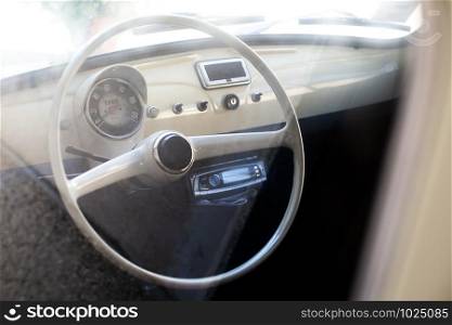 White interior of vintage car. White steering wheel.