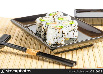 white Japanese rolls on a black dishes, shot in studio