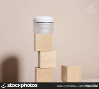 white jar for cosmetics on a beige table. Packaging for cream, gel, serum, advertising and product promotion, mock up