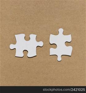 white jigsaw puzzle piece brown paper textured backdrop
