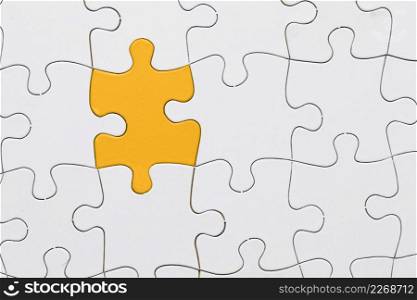white jigsaw puzzle sheet with yellow puzzle piece center