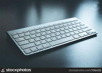 White keyboard lying on the grey table