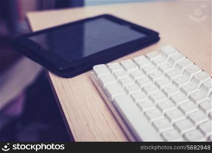 White keyboard with a black tablet next to it on desk