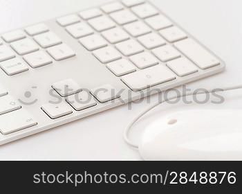 White keyboard with computer mouse close up on business desk