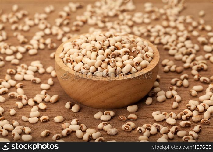 white kidney bean in wooden bowl and heap on wood background