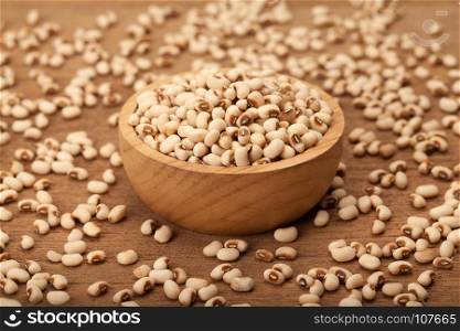 white kidney bean in wooden bowl and heap on wood background