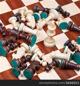 white king and scattered chess pieces on chessboard