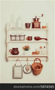 White kitchen shelves in rustic style with kitchenware on the white wall. Shelves in rustic style