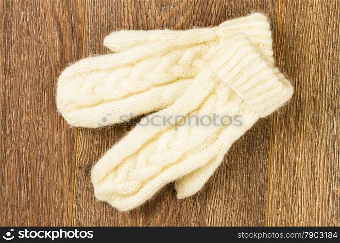 white knitting mittens on wooden background