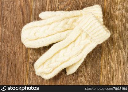white knitting mittens on wooden background