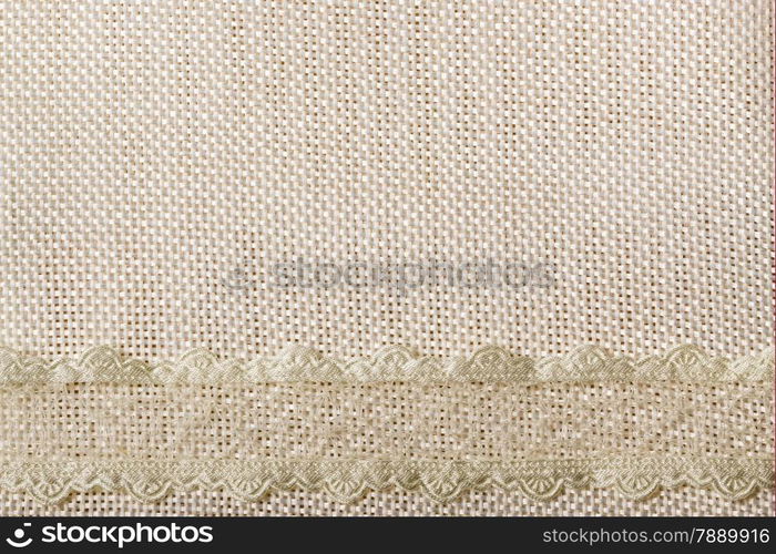 White lace ribbon frame on light material, sack cloth background