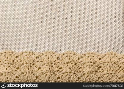 White lace ribbon frame on light material, sack cloth background