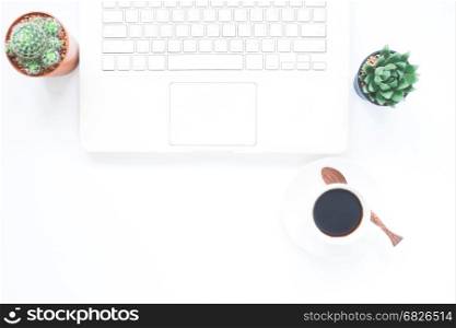 White laptop computer with cup of coffee and cactus on white modern workspace