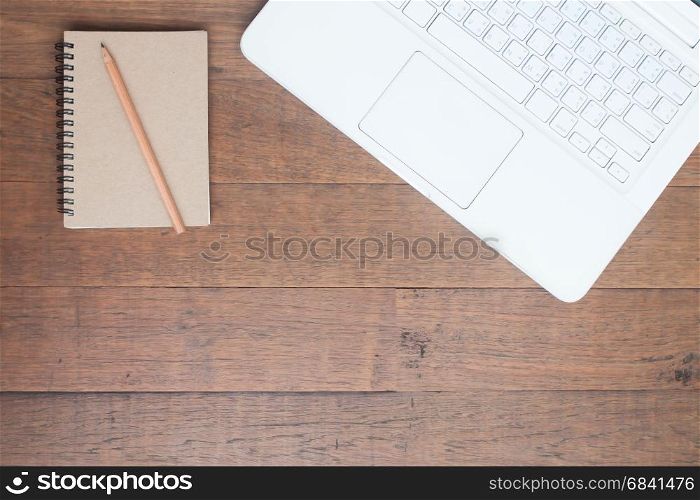 White laptop computer with notebook on wooden table, Workspace concept