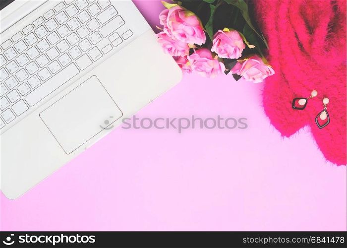 White laptop computer with woman accessories and pink roses on pink background, Lifestyle concept with copy space