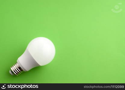White light bulb on a green background with copy-paste space for text