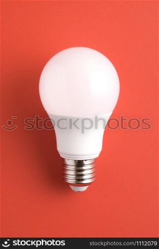 White light bulb on red background