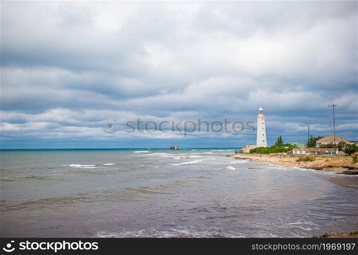 White lighthouse in a bay at the sea. White lighthouse in a bay at sea