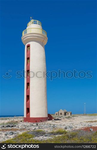 white lighthouse with ruin on coast of island Bonaire