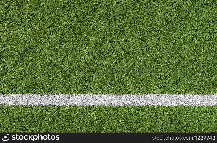 White line marking on green turf of a sports field viewed from above as a lower border with background copy space
