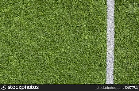 White line marking on green turf of a sports field viewed from above as a lower border with background copy space