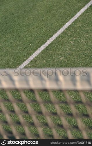 white line on an outdoor tennis court (defocused net)