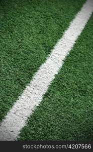 White line painted on green grass. Soccer field shot.